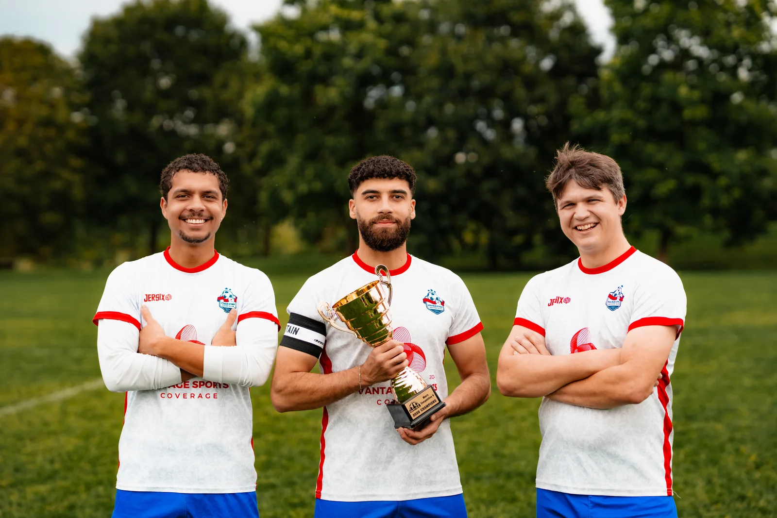 Three Inter Ottawa MC4 players posing with the division trophy