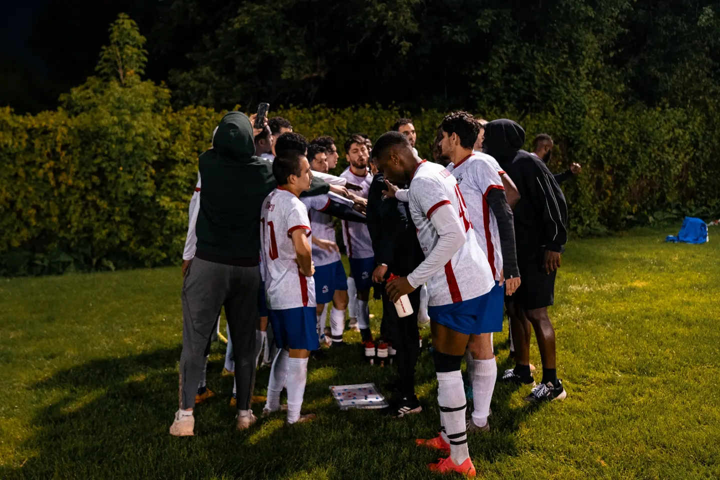 Inter Ottawa players in a night-time huddle