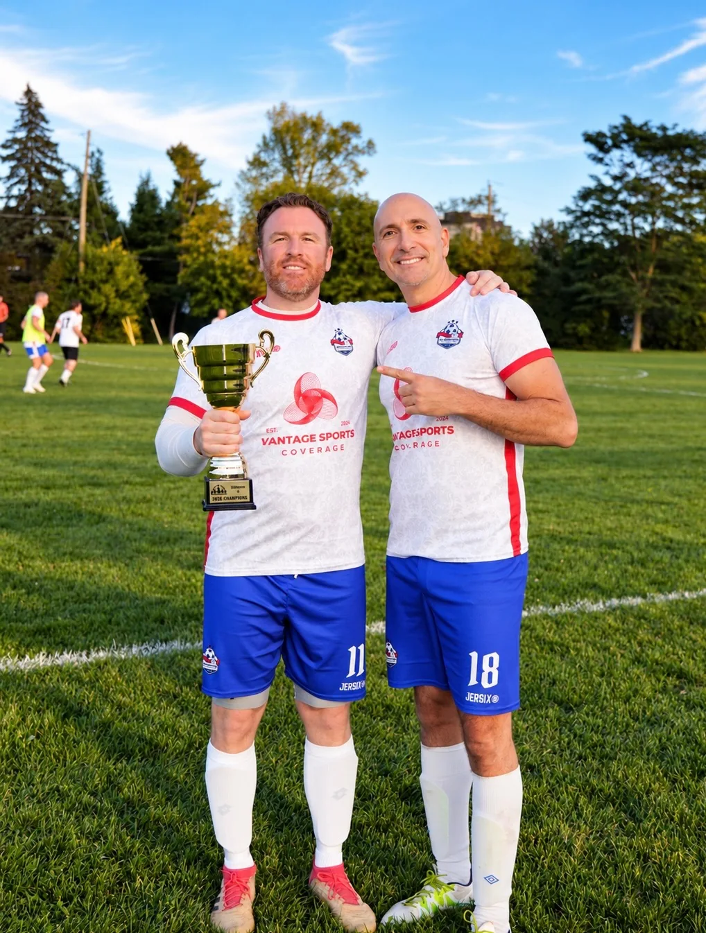 Two Inter Ottawa OT3 players posing together with the 2026 division trophy